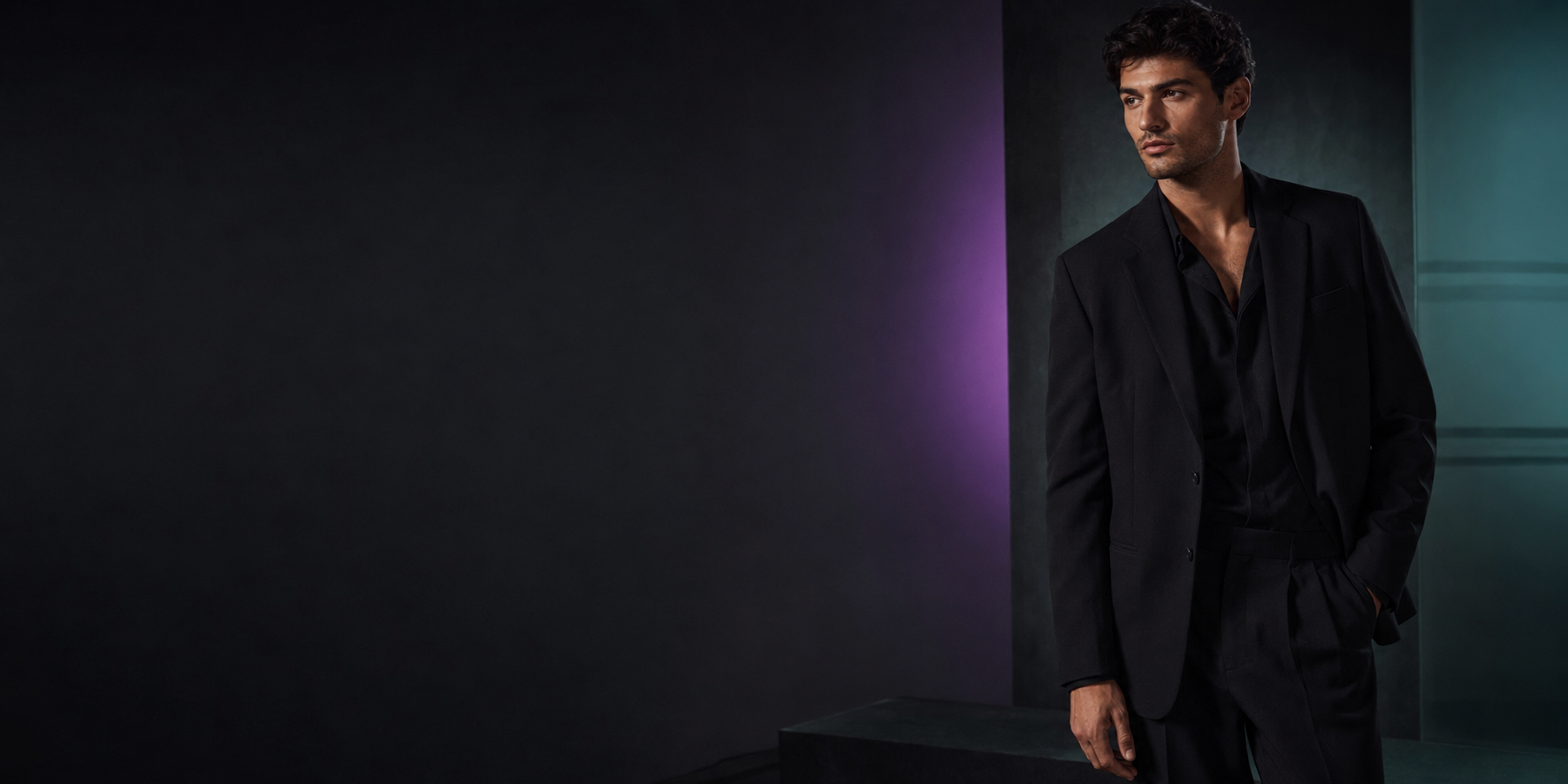 Male model wearing a black tailored suit in a dark HOBZ brand studio